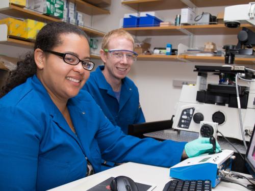 Student and research mentor with microscope