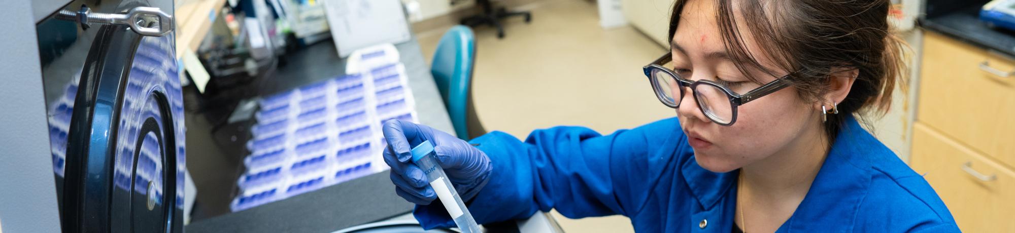 Close-up of a PREP@UC Davis scholar loading a sample into a centrifuge